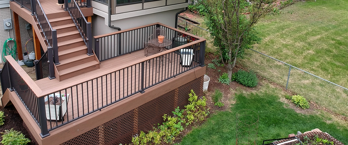 A two level deck with a set of stairs and metal frame