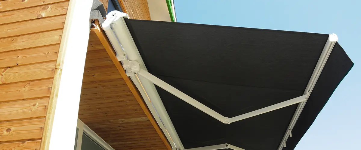 A black retractable awning above a deck