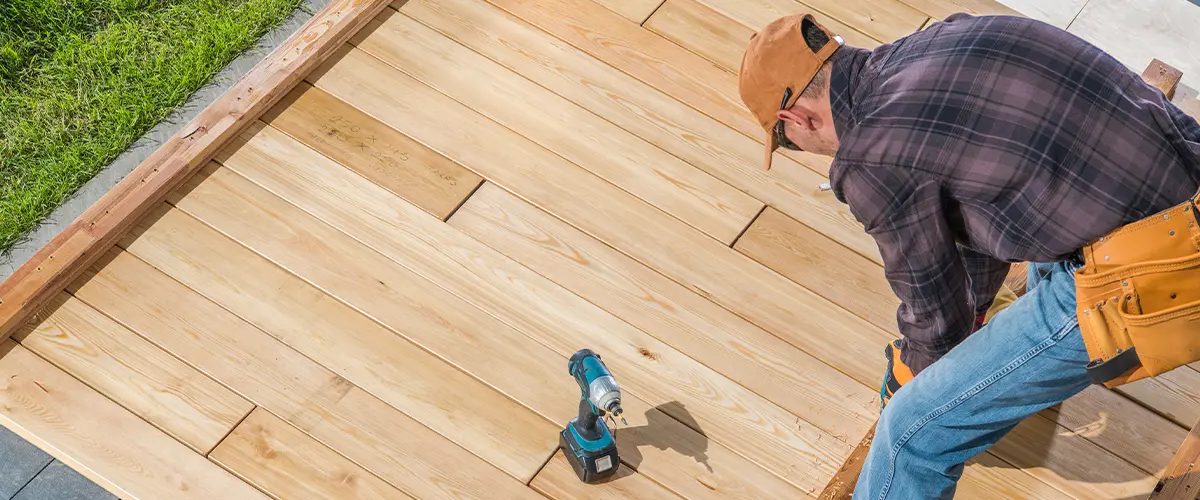 Contractor attaching decking and installing decking boards