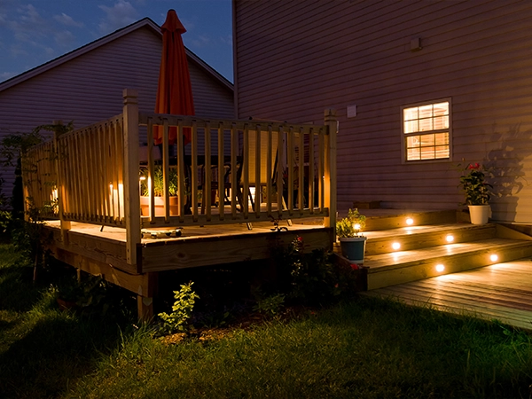 A ground level deck at night with deck lightings on stairs