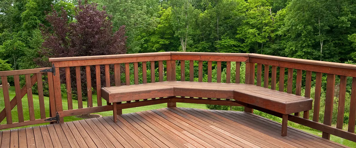 A drinking rail on a wood deck with a bench