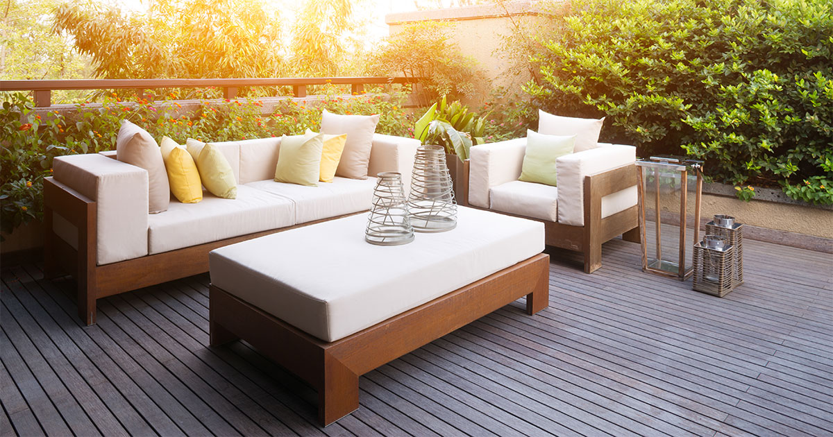 A wood deck with furniture and a white couch