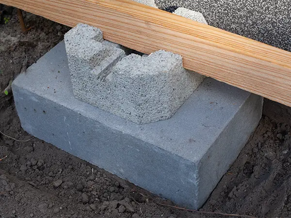 Concrete deck blocks with a piece of wood