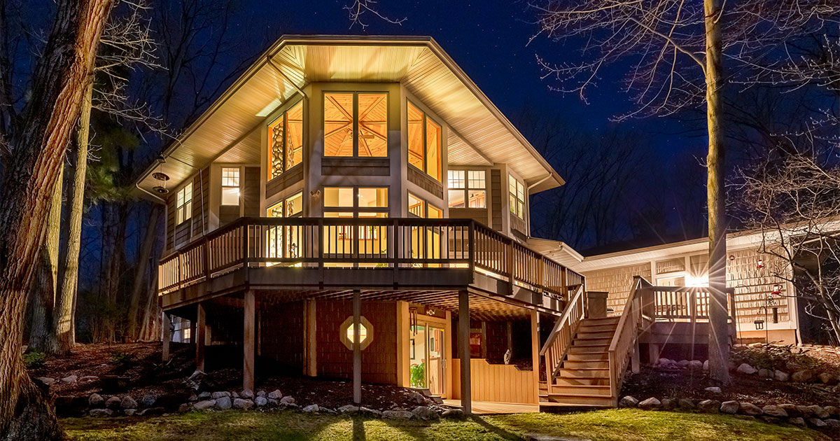 A two level deck with railings on a big mansion