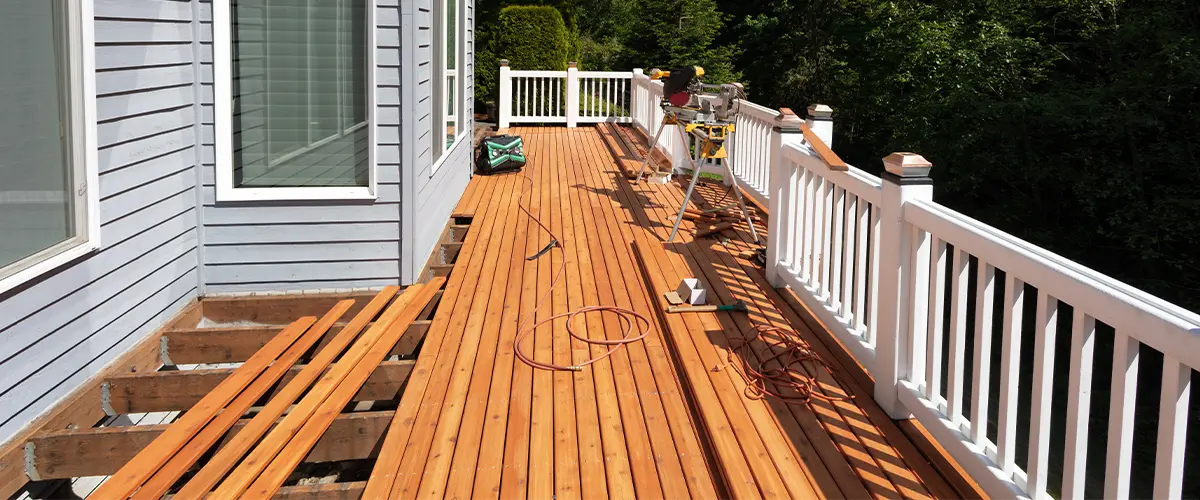 Outdoor red wooden cedar deck being remodeled with new floor boards freshly installed