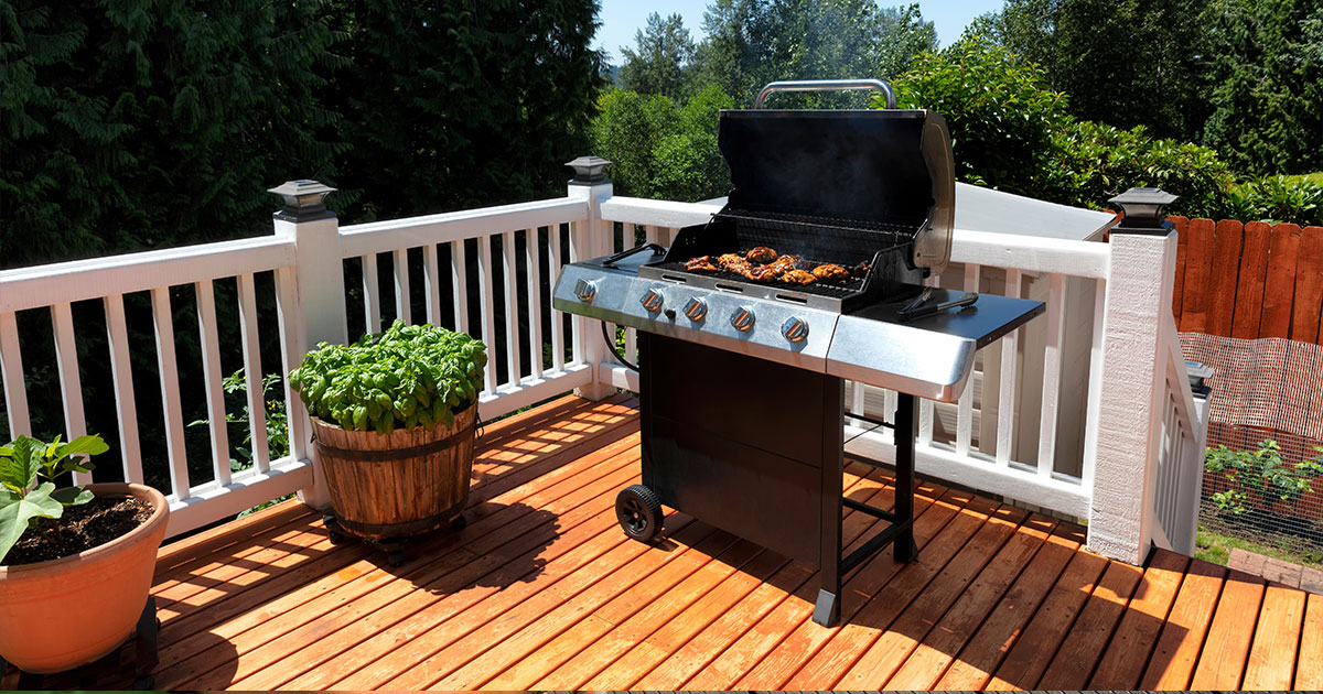 A well-maintained wooden deck with a grill and plants, showcasing the effectiveness of the Best Deck Stain Stripper in Annapolis.