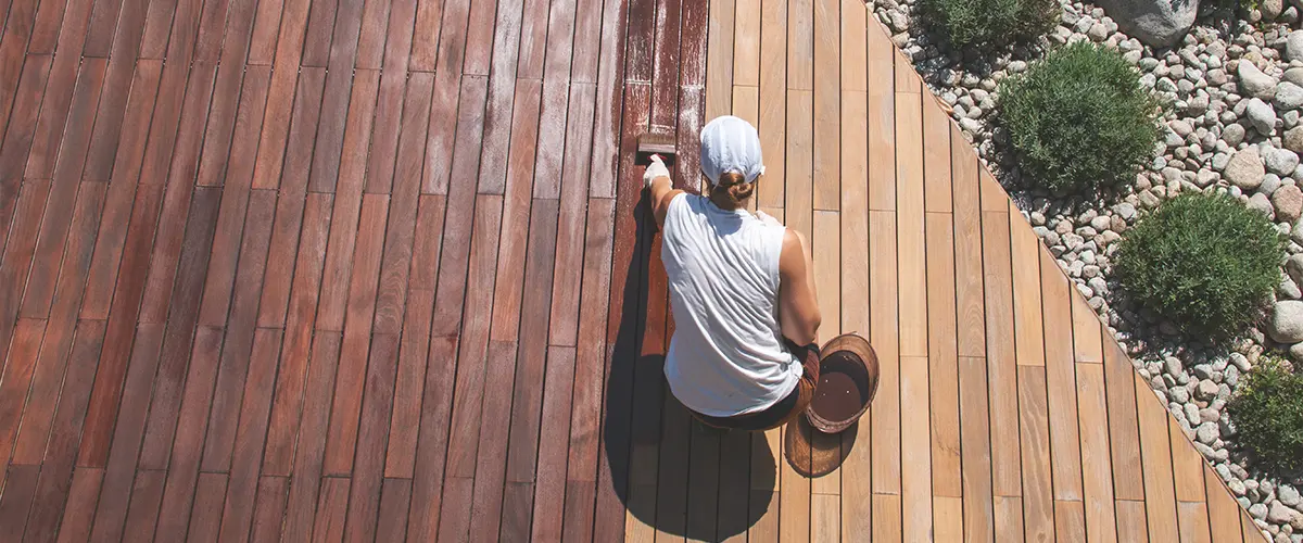 Applying wood stain to a wooden deck for restoration.