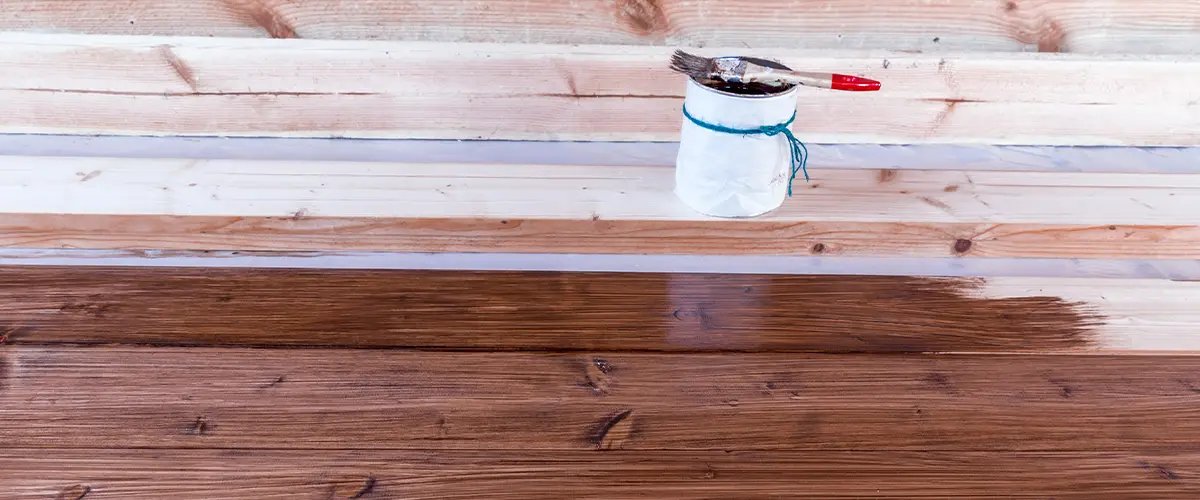 Wood floor being stained with dark wood finish during renovation.